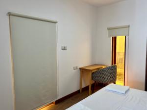 a bedroom with a bed and a desk and a window at Nebo Apartments Paje in Paje