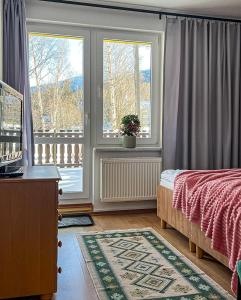 Schlafzimmer mit einem Bett und einem Fenster mit einem Balkon in der Unterkunft Willa RADosna in Karpacz