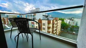 balcón con 2 sillas y vistas a la ciudad en Estupendo apartamento con ubicación estrategica en el norte de la ciudad, en Armenia