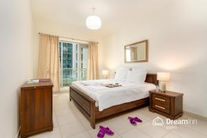 a bedroom with a bed with purple shoes on the floor at Dream Inn Apartments - Boulevard Central in Dubai
