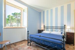 Un dormitorio con una cama azul y una ventana en Casale Stabbiatelli by VacaVilla, en Montenero