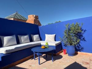 eine blaue Couch und ein Tisch auf einer Terrasse in der Unterkunft Jolie petit Riyad avec piscine belle terrasse wifi in Marrakesch