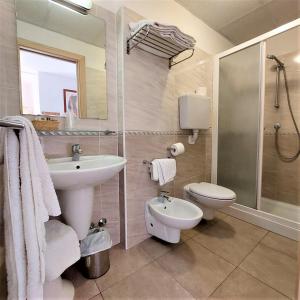 a bathroom with a sink and a toilet and a shower at Hotel Ornella in Lido di Jesolo +34 photos