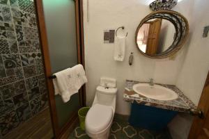 een badkamer met een toilet, een wastafel en een spiegel bij Casa Morasan Hotel-Boutique in Quetzaltenango