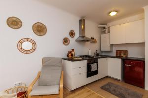 La cuisine est équipée de placards blancs et d'un four avec plaques de cuisson. dans l'établissement Cosy brand new Apartment, à Vienne