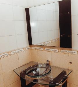 a bathroom with a glass sink and a mirror at Two bedroom Apartment in Oyster Bay in Dar es Salaam