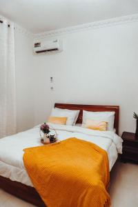 a bedroom with a large bed with an orange blanket at Two bedroom Apartment in Oyster Bay in Dar es Salaam