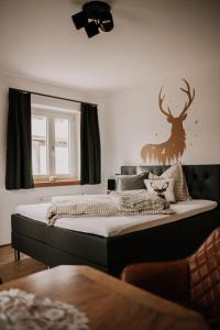 Dormitorio con cama con ciervo en la pared en Wohnung Hochalm, en Lenggries