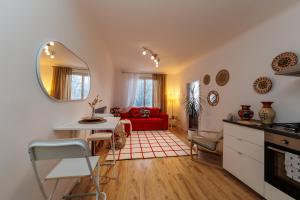 cocina y sala de estar con sofá rojo en Cosy brand new Apartment, en Viena