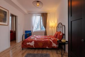 1 dormitorio con 1 cama con manta roja y ventana en Cosy brand new Apartment, en Viena