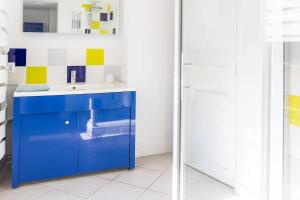 y baño con lavabo azul y espejo. en Maison 'Millésime' spacieuse et confortable, en Hautvillers