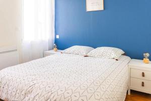 1 dormitorio con cama blanca y pared azul en Maison 'Millésime' spacieuse et confortable, en Hautvillers