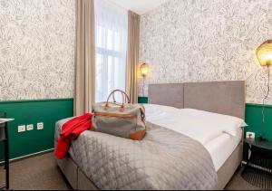 une chambre d'hôtel avec un lit avec un sac dans l'établissement Casa, à Hradec Králové