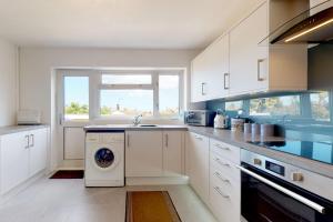 a kitchen with a washing machine and a window at Alberts Retreat in Abergele