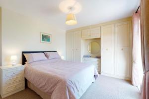 a bedroom with a bed and a dresser and a mirror at Alberts Retreat in Abergele