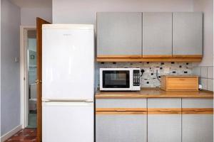 a kitchen with a white refrigerator and a microwave at Aderyn Du in Abergele