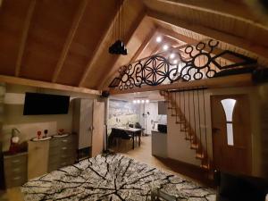 a room with a staircase and a living room with a table at Domek na szlaku RIKARDO in Ponice