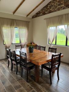 a dining room with a wooden table and chairs at Cabbage Cottage in Lidgetton