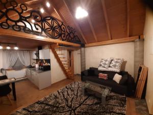 a living room with a couch and a loft at Domek na szlaku RIKARDO in Ponice