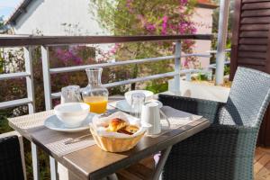 uma mesa com uma cesta de comida e um copo de sumo de laranja em Zenitude Hôtel-Résidences Le Cannet em Le Cannet