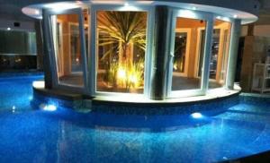 una casa con piscina con palmeras en Linda Bay Beach & Resort Studio 304 en Mar de las Pampas
