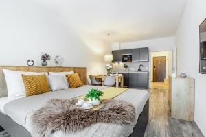 a bedroom with a large white bed with a furry rug at KORZO LIPNO 2 in Lipno nad Vltavou