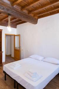 ein großes weißes Bett in einem Zimmer mit Holzdecken in der Unterkunft Sweet Apartment Near Piazza Pitti in Florenz