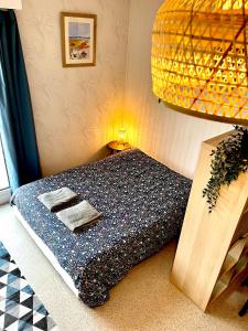1 dormitorio con cama, lámpara y mesa en Ma Location Sablaise - Appart’ Le Quai en Les Sables-dʼOlonne
