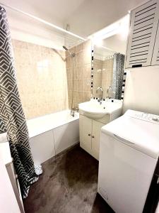 y baño con lavabo, bañera, aseo y lavamanos. en Ma Location Sablaise - Appart’ Le Quai en Les Sables-dʼOlonne