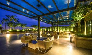 an outdoor patio with chairs and tables at night at The Light Hotel Penang in Perai