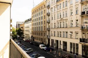 PiotrApartments Luxury Apartments in City Centre في وارسو: شارع المدينة فيه سيارات ومباني متوقفة