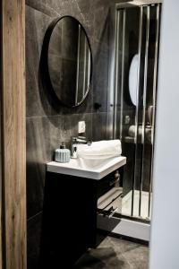 a bathroom with a sink and a mirror at PiotrApartments Luxury Apartments in City Centre in Warsaw