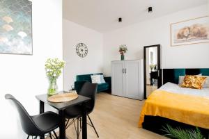 a bedroom with a bed and a table and chairs at PiotrApartments Luxury Apartments in City Centre in Warsaw
