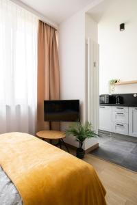 a bedroom with a large bed and a kitchen at PiotrApartments Luxury Apartments in City Centre in Warsaw