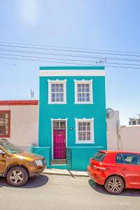 a blue house with two cars parked in front of it at Shortmarket 136 in Cape Town