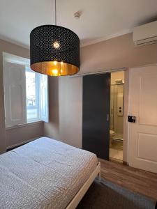 a bedroom with a bed and a large light fixture at Suites & Apartments DP VFXira in Vila Franca de Xira