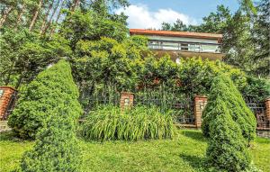 una casa con una valla y plantas en el patio en Awesome Apartment In Stawiguda With Kitchen, en Stawiguda