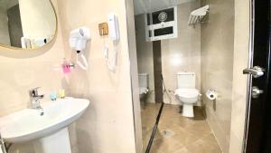 un bagno con lavandino, water e specchio di Concorde Inn Hotel a Dubai