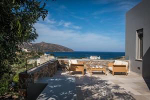 eine Terrasse mit Stühlen und Meerblick in der Unterkunft HERMIONE 3-Bedroom Villa in Agios Nikolaos in Agios Nikolaos