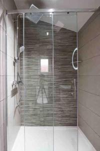 a shower with a glass door in a bathroom at Modern 2 bed flat near Wembley Stadium in London