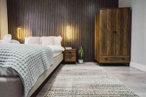 een slaapkamer met een groot bed en een houten muur bij Modern 2 bed flat near Wembley Stadium in Londen