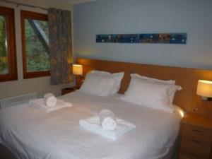 a bedroom with a white bed with two towels on it at Keswick Bridge 13 in Keswick