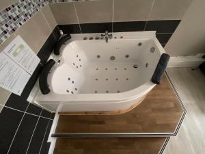 a bath tub in a bathroom with black tiles at Les appartements d'Au Coin Du Spa in Boulogne-sur-Mer +63 photos