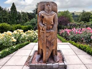 een beeld van een god in een tuin bij Castlegate in Lanark