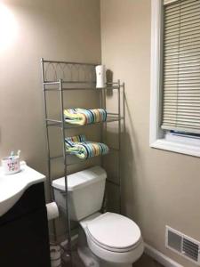 a bathroom with a toilet and a shelf with towels at The Salt Life- Entire Home 8 Bdrm 3bath & GameRoom in Seaside Heights
