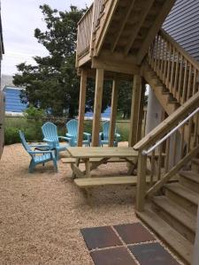 a wooden picnic table and chairs in a backyard at The Salt Life- Entire Home 8 Bdrm 3bath & GameRoom in Seaside Heights