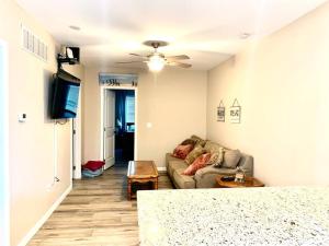 a living room with a couch and a flat screen tv at The Salt Life- Entire Home 8 Bdrm 3bath & GameRoom in Seaside Heights