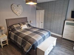 1 dormitorio con 1 cama y pared cardiaca en Bounty Town House Cumbria, en Whitehaven