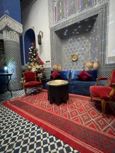 a living room with a blue couch and a christmas tree at Riad D'or meknes in Meknès