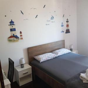 a bedroom with a bed with lighthouse stickers on the wall at Rooms Providenca in Gradac